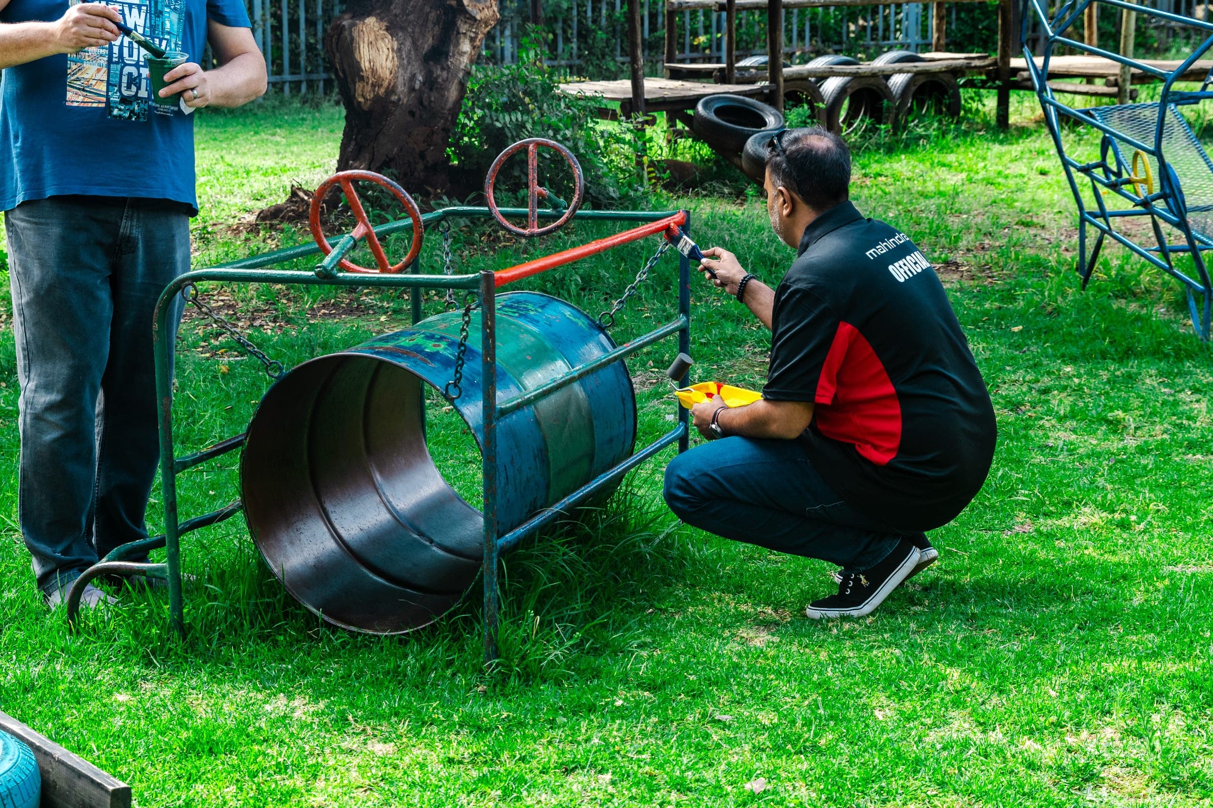 Mahindra volunteer working on an outdoor metal and wood structure