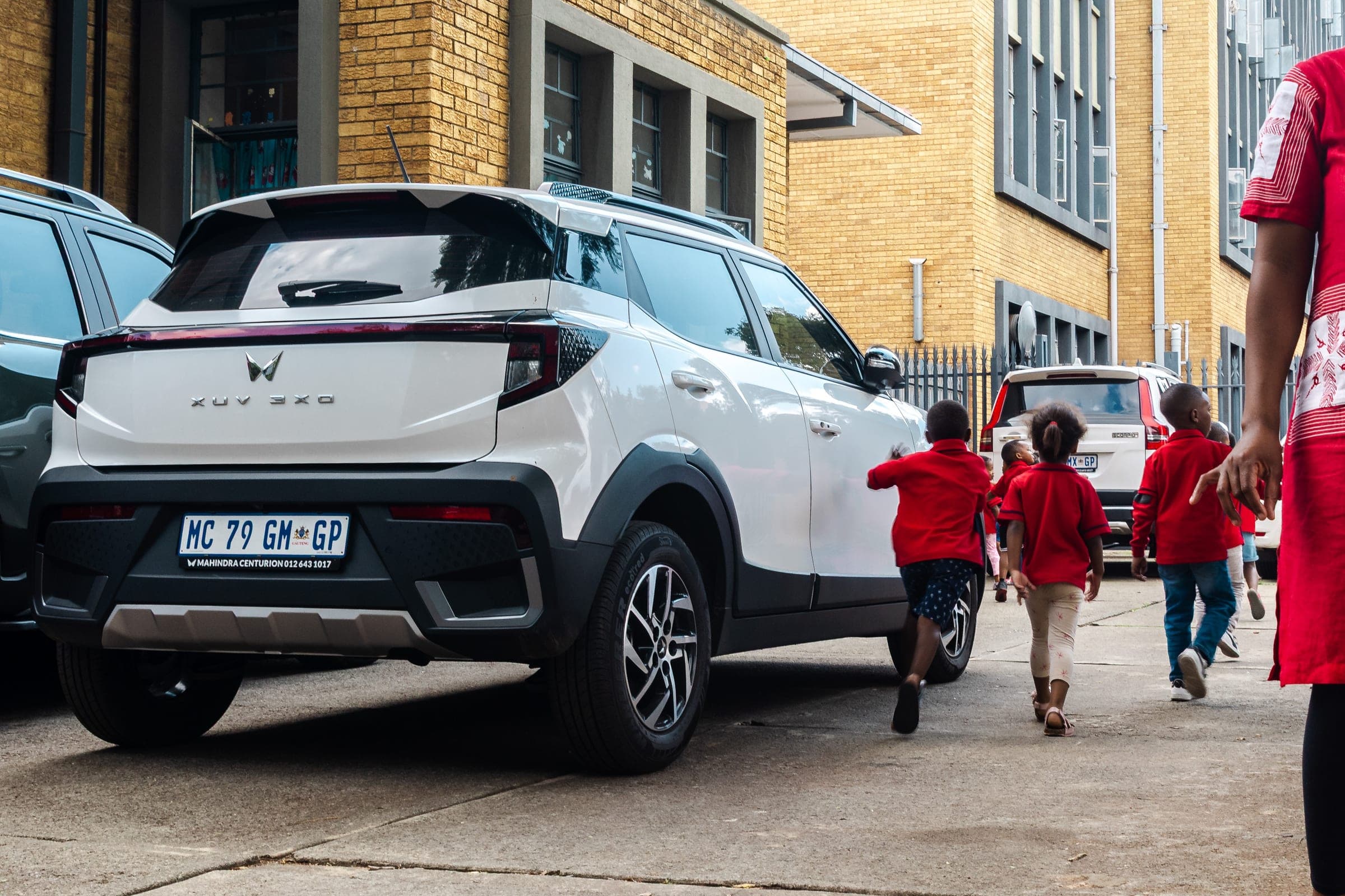 Children walking past a Mahindra XUV 3XO during a Care Fest community event