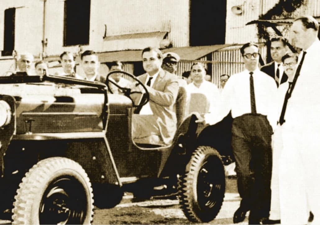 Historical Mahindra vehicle with a group of people