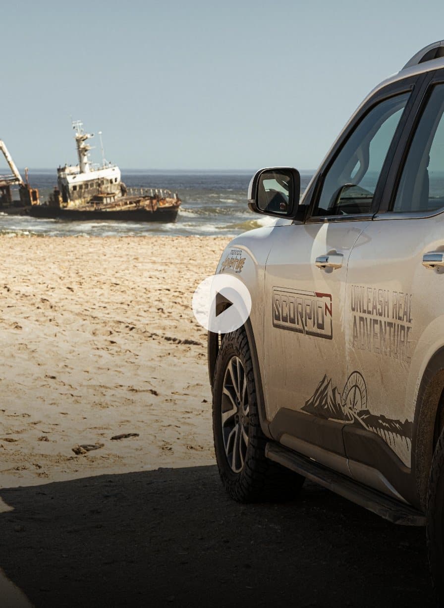 Mahindra Scorpio-N parked on the Skeleton Coast beach beside a shipwreck