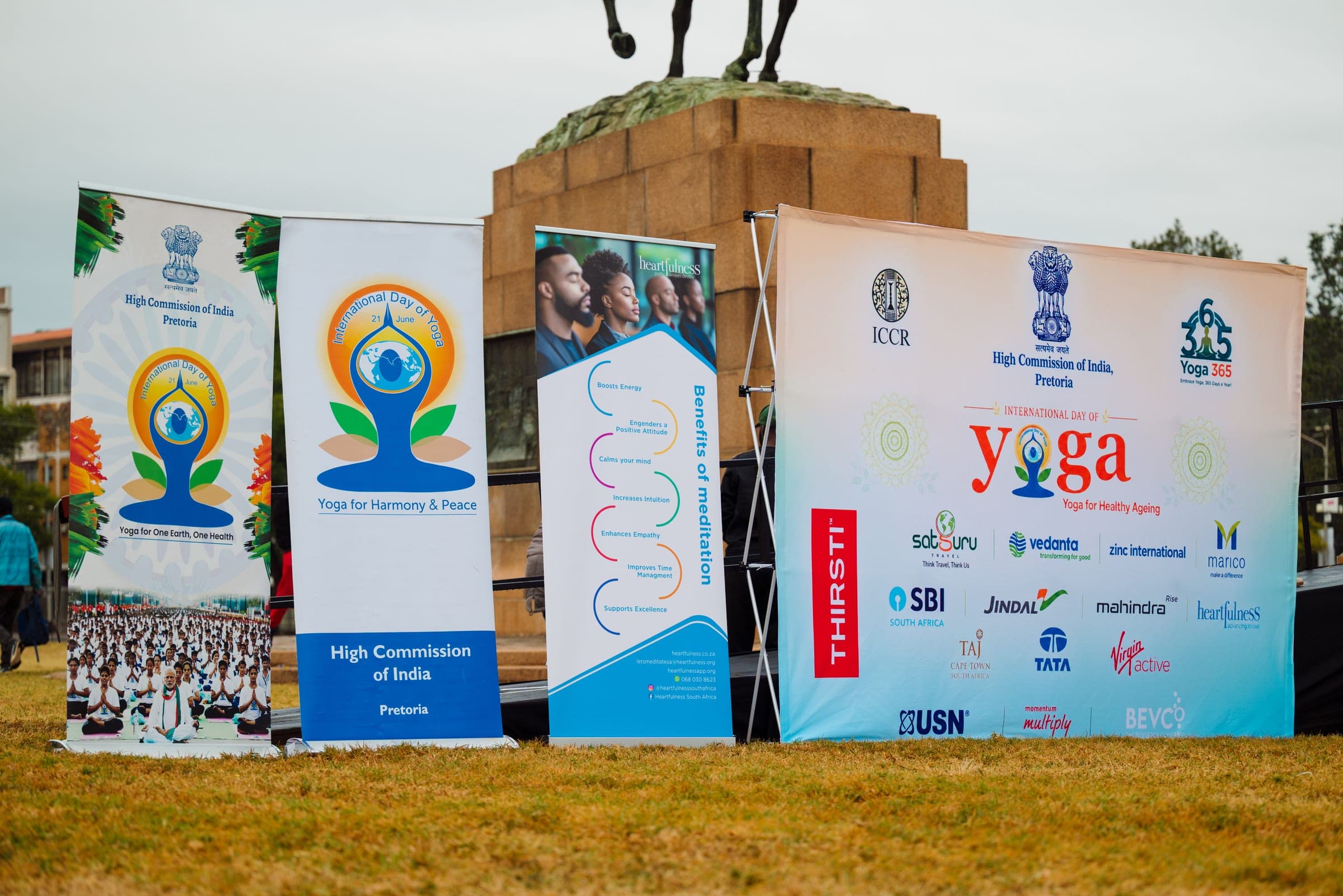 International Day of Yoga banners and sponsor backdrop including Mahindra at the Pretoria event