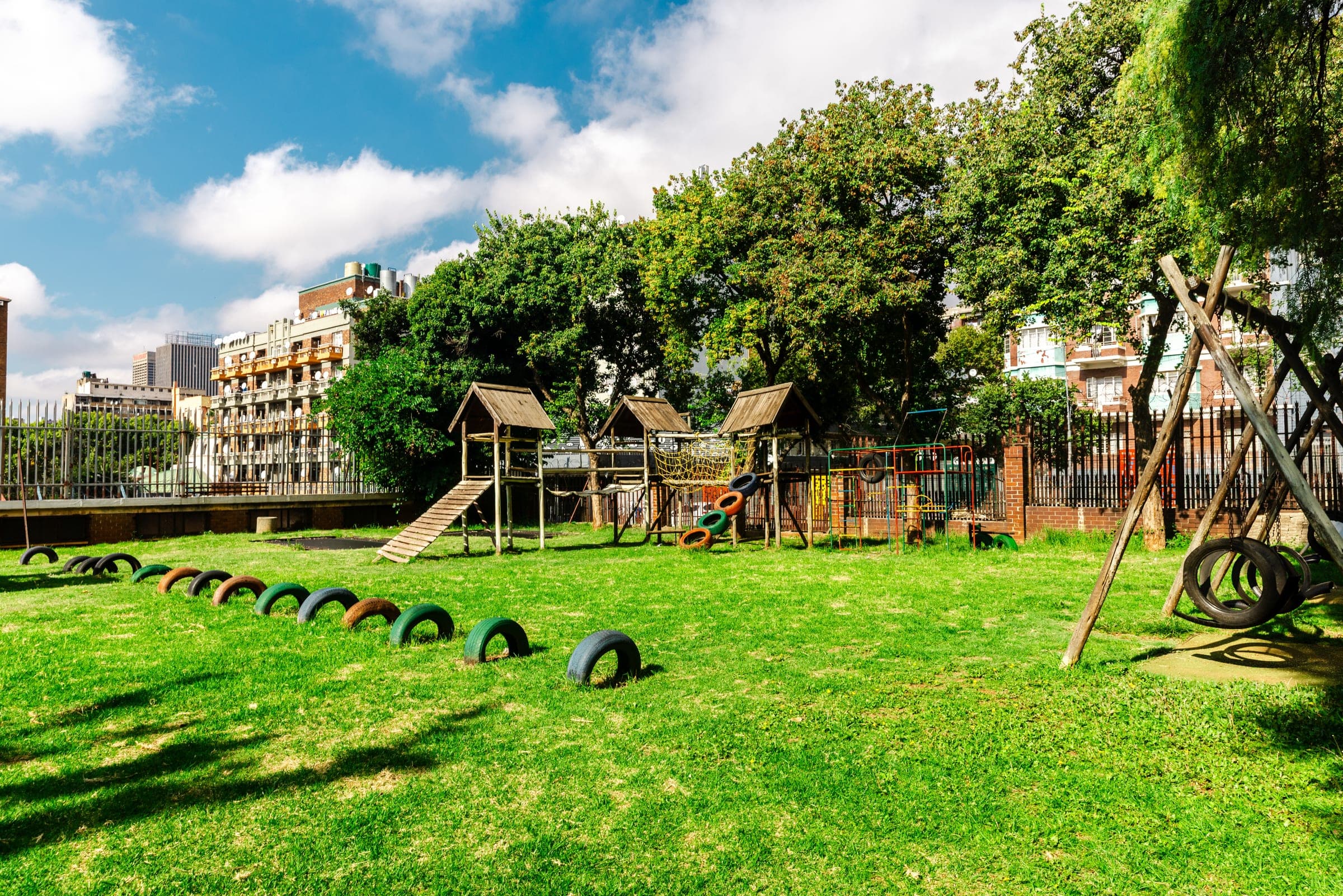 Playground area at Dinaledi Crèche with green grass and play structures